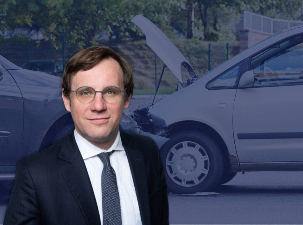 Mann im Anzug vor Autounfall